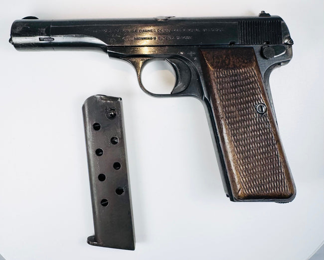 Deactivated FN Browning Model 1922 displayed with its magazine removed, revealing slide lettering and aged steel surfaces.