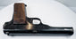 FN Browning Model 1922 resting on a white surface, showing the narrow slide, rounded barrel contours, and walnut grip base.