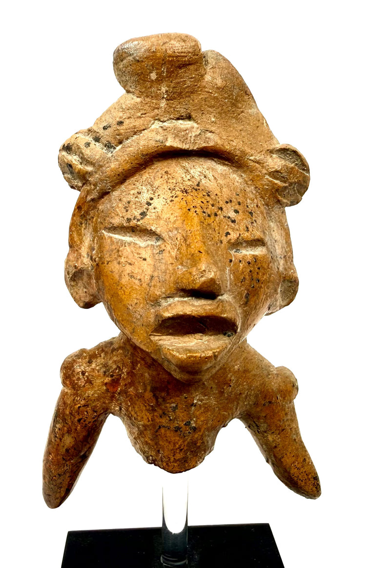 Close-up of terracotta bust with expressive open mouth and mineral speckles
