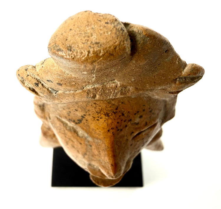Top-down view of terracotta headdress structure and speckled clay texture