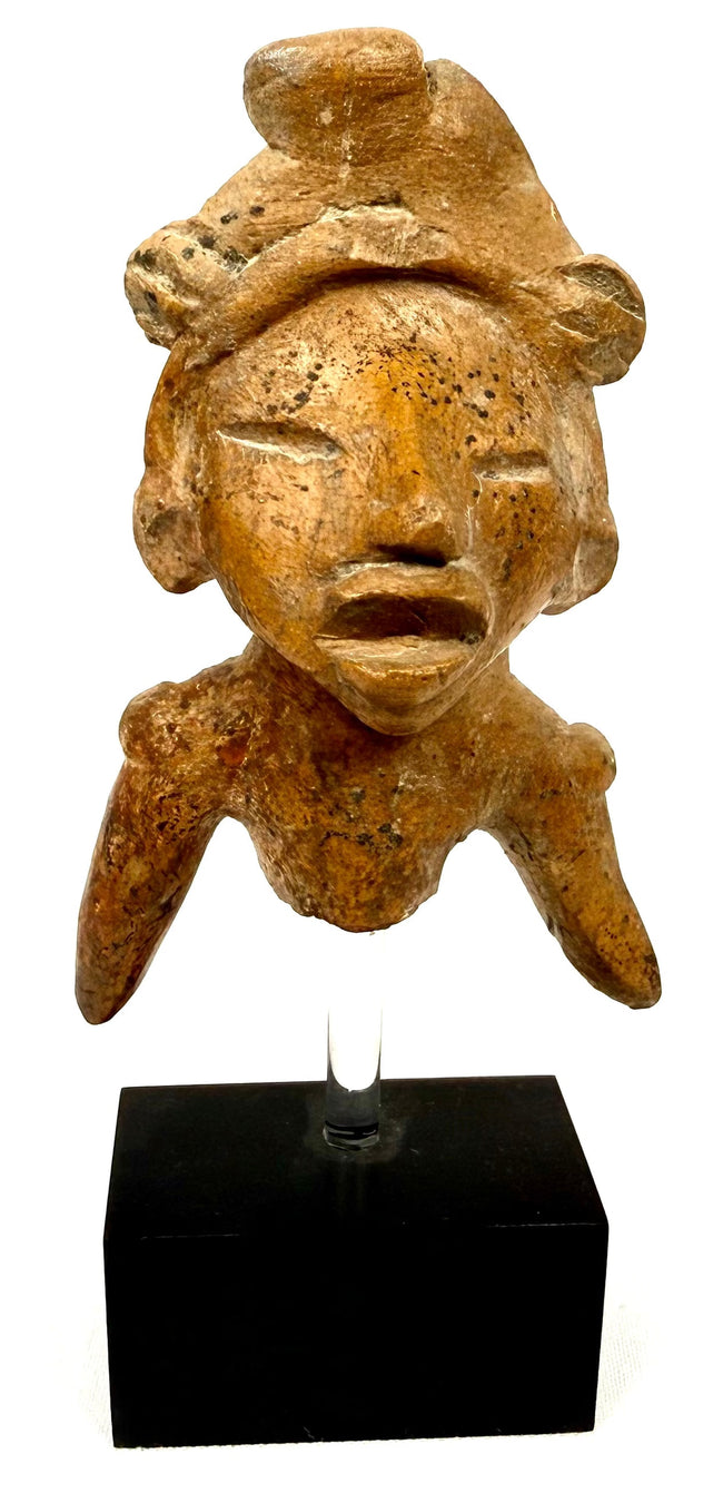 Orange-brown fired clay torso fragment showing incised eyes and textured surface