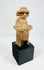 Terracotta effigy with turban-style headdress, large earspools, hands-to-chest pose, circular back disk