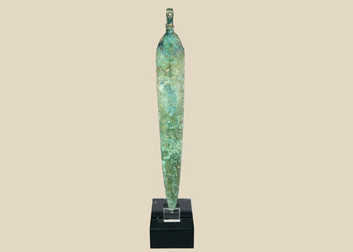 Ancient Western Asiatic bronze dagger blade, 1st millennium BCE, with tapered form, central spine, perforated base, and green patina.