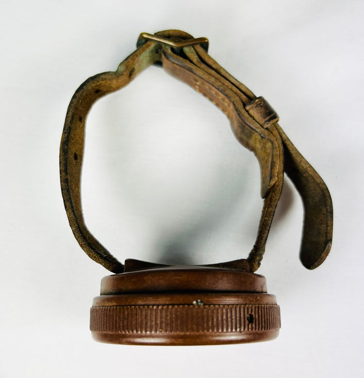 WWI memorabilia set featuring wrist compass, shell casing, and sepia-toned unit photograph