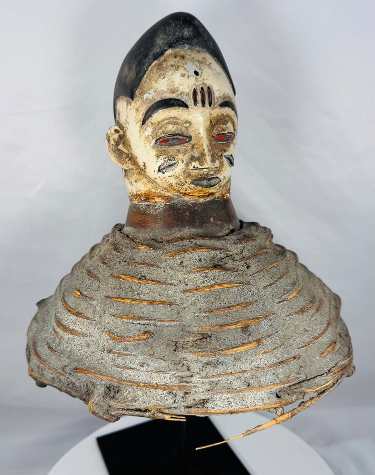 Mid-20th century Yoruba Egungun ceremonial headdress with white-painted face, red eyes, and woven fiber structure.