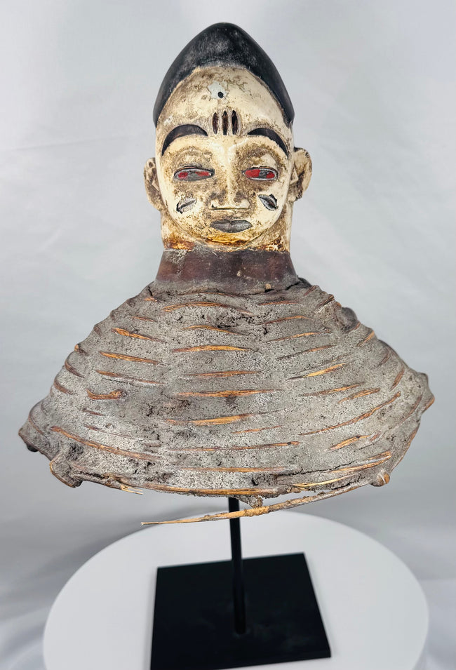 African Yoruba ancestor masquerade headdress displaying carved wood construction and surviving wicker costume framework.