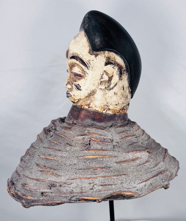 Yoruba Egungun ancestral headdress featuring black coiffure, painted wood face, and surviving costume framework.
