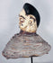 Yoruba Egungun ancestral headdress featuring black coiffure, painted wood face, and surviving costume framework.