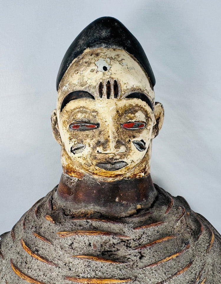Authentic Yoruba Egungun ceremonial artifact with white pigment, red eyes, and woven costume support structure.