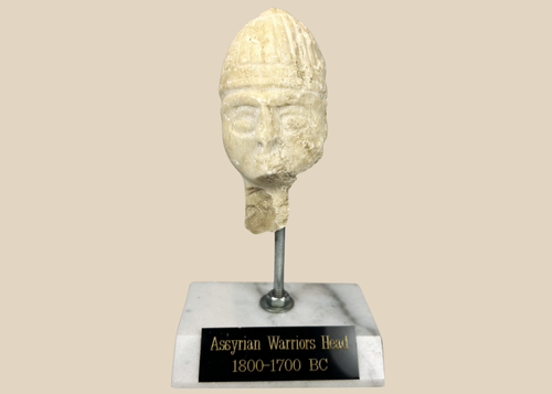 Ancient Assyrian stone warrior head with ribbed helmet