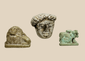 Ancient Egyptian Hathor amulet, stone lion figurine, and Greco-Roman carved head displayed together in a custom acrylic mount.