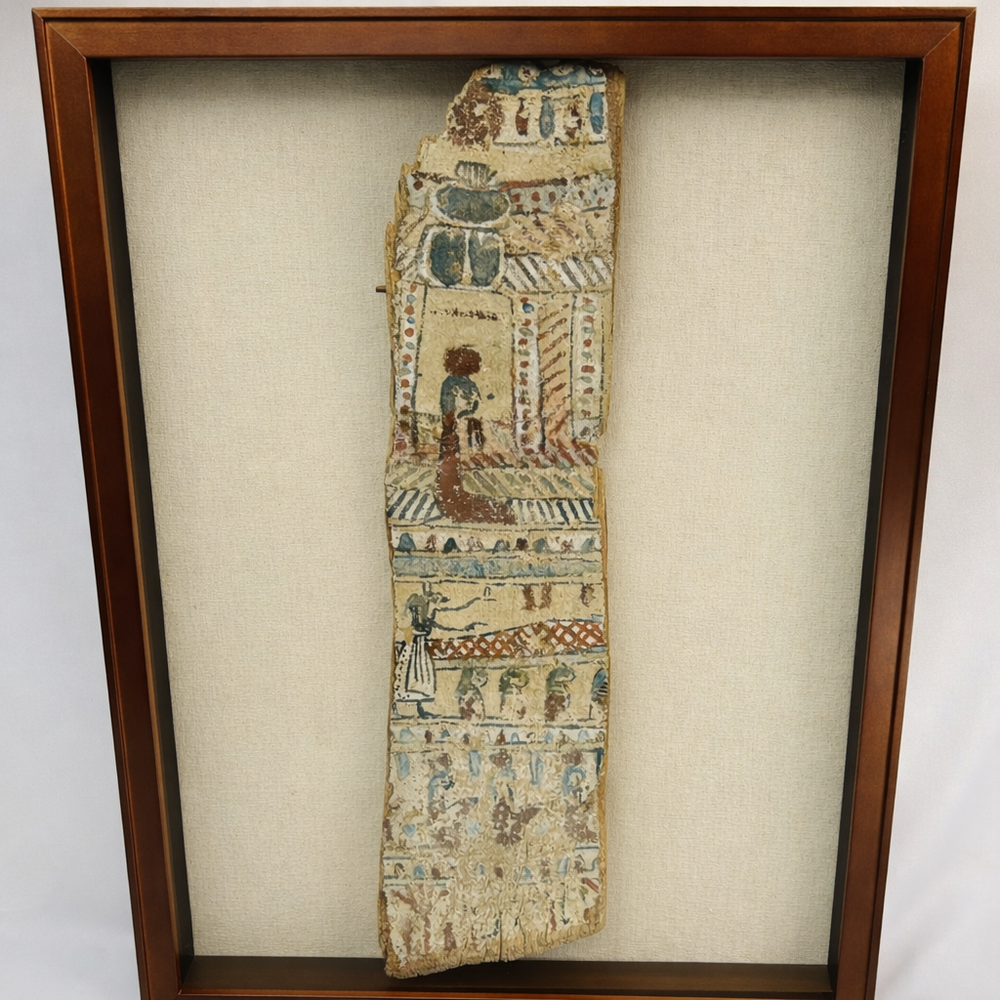 Framed ancient Egyptian painted coffin fragment with polychrome hieroglyphic and figural decoration displayed against a neutral background