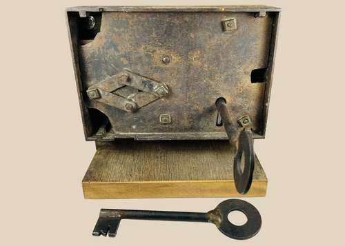 Antique 19th century iron rim lock with skeleton key on display