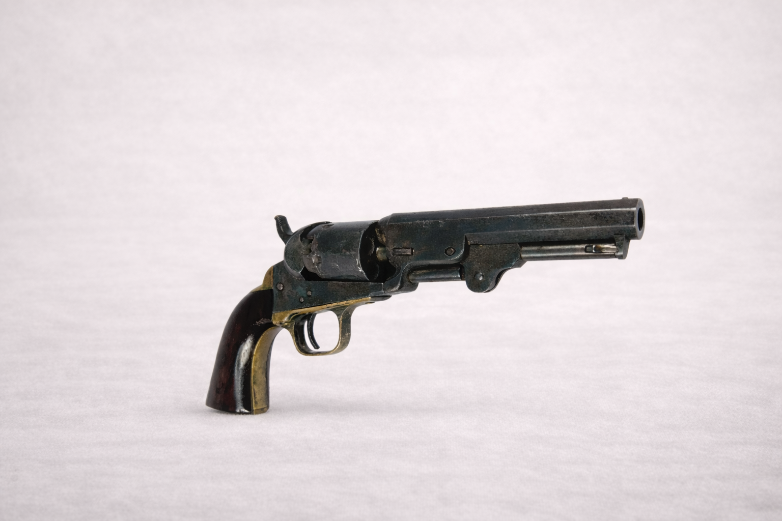 Antique 19th century percussion revolver with wooden grip, black powder pistol displayed on neutral background