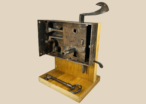 Antique iron door lock mechanism with visible internal bolts and large key