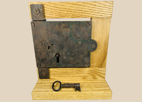 Antique 19th century iron rim lock with original skeleton key on display