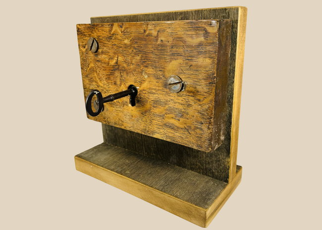 Antique mortise door lock with skeleton key mounted on wooden display
