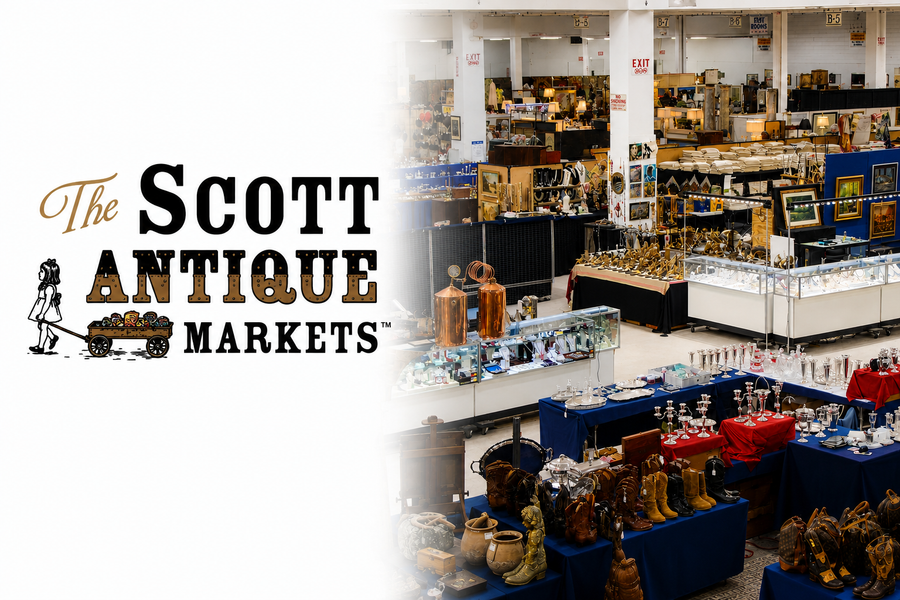 Wide interior view of an antique show featuring display cases, artwork, silverware, jewelry, furniture, collectibles, and vintage items arranged throughout the exhibition hall.