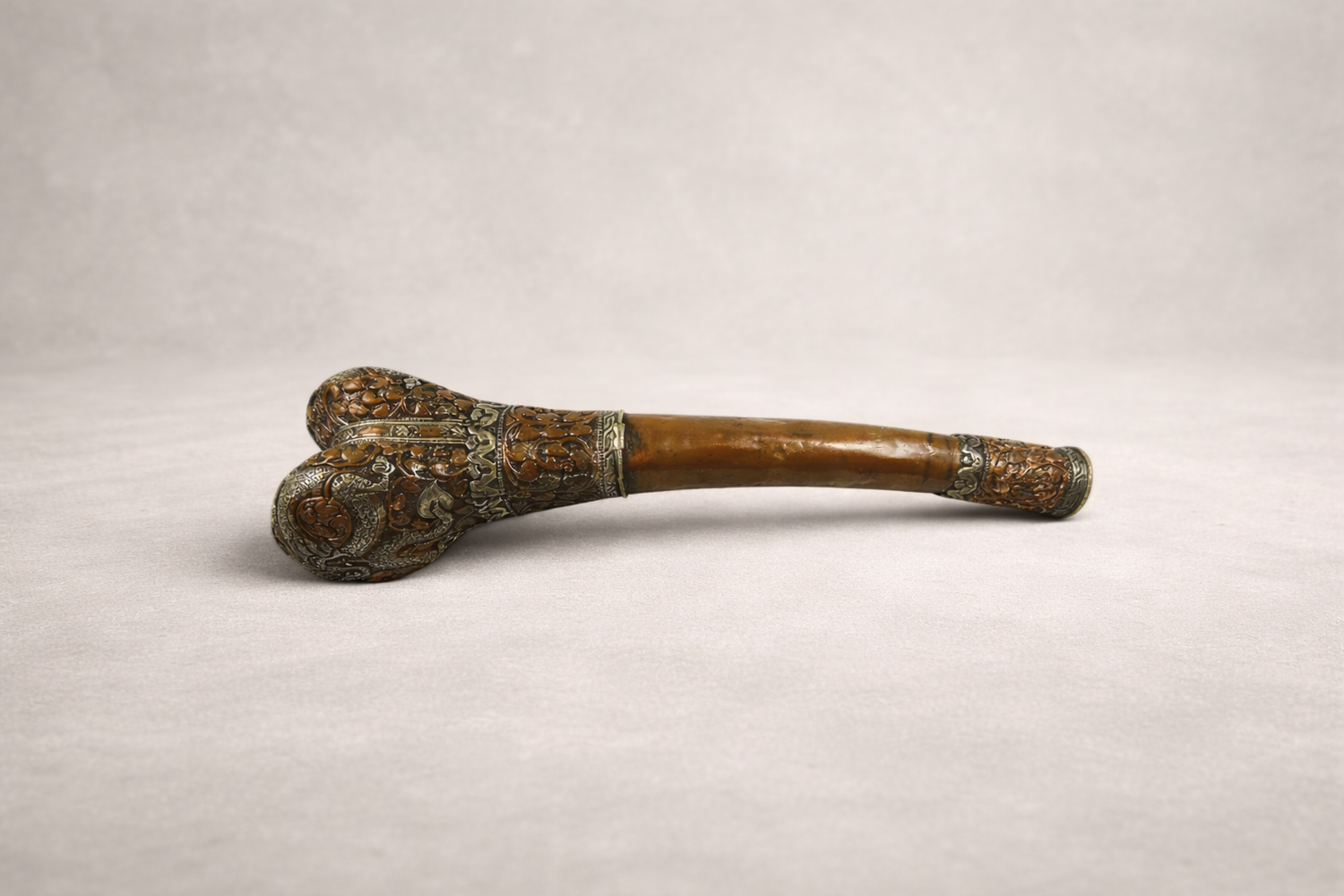 Antique Tibetan kangling ritual trumpet with carved bone and metal mounts, Buddhist ceremonial instrument on neutral background