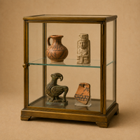 Historical pottery, carved figures, and decorative objects preserved inside a glass display cabinet for safe long-term presentation.