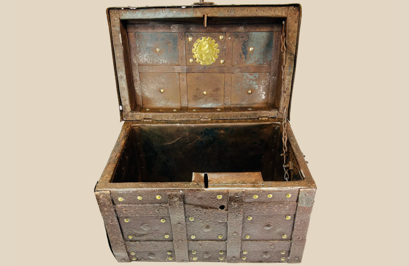 Iron-bound wooden strongbox from Spain or Portugal with brass studs and reinforced lid, early modern period, shown open on beige background