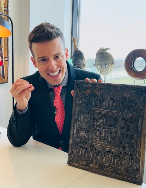 Jordan Thomas, Founder and Head Curator of Relic & Rarity, presenting an ancient Egyptian-style bronze relief panel during an artifact research and authentication session at the gallery, highlighting the company's expertise in historical antiquities and provenance research.