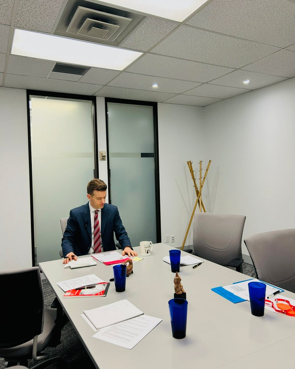 Jordan Thomas, Founder and Head Curator of Relic & Rarity, reviewing documents during a business meeting at the company's Markham, Ontario office, reflecting the research, authentication, and provenance process behind every historical artifact.