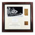 Front view of framed Egyptian mummy-wrapping fragments with a historic photograph, handwritten inscription and identification panel.