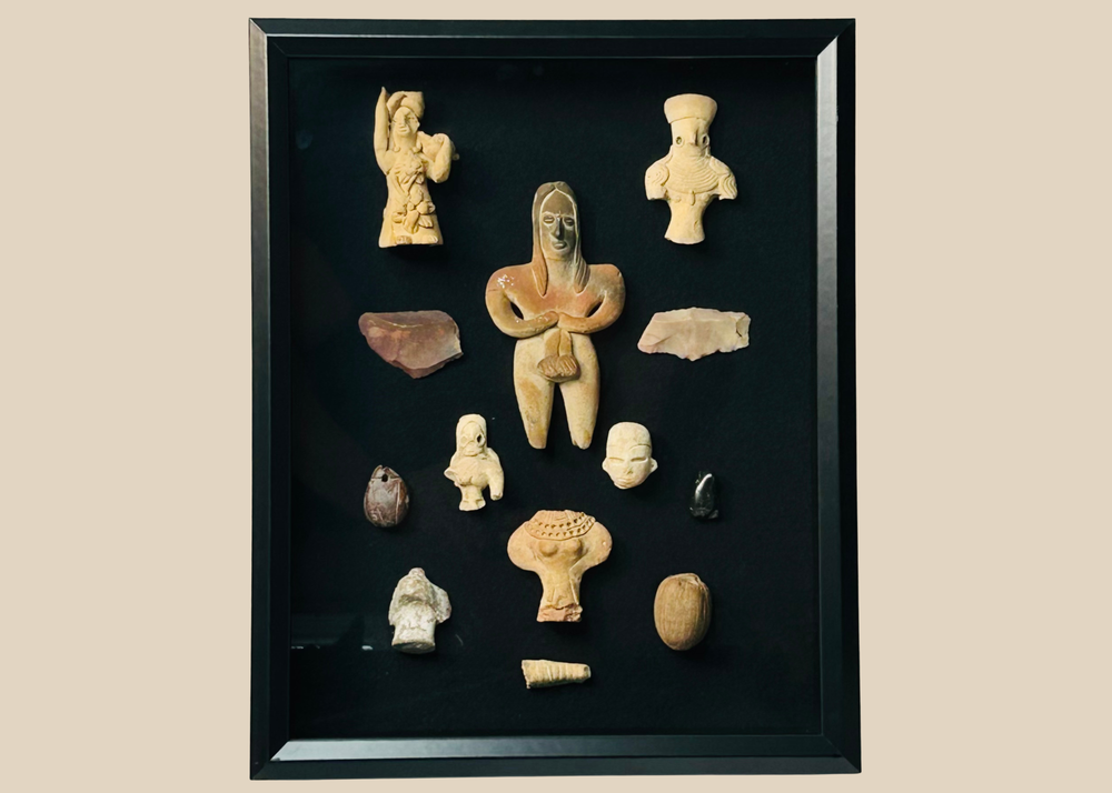 Framed collection of Pre-Columbian terracotta and stone artifacts displayed in a shadowbox.