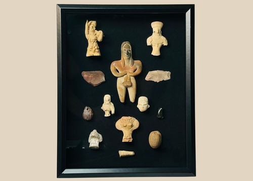 Framed collection of Pre-Columbian terracotta and stone artifacts displayed in a shadowbox.