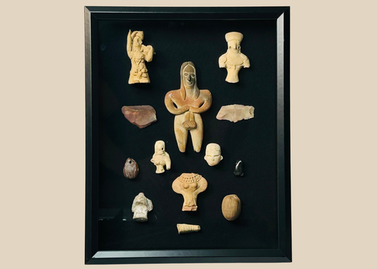 Framed collection of Pre-Columbian terracotta and stone artifacts displayed in a shadowbox.