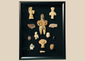 Framed collection of Pre-Columbian terracotta and stone artifacts displayed in a shadowbox.
