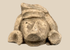 Pre-Columbian carved stone head fragment with recessed eyes, triangular nose, and circular earspools