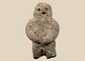 Pre-Columbian carved stone standing figure with folded arms and deeply recessed eyes