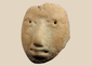 Pre-Columbian terracotta human head fragment with stylized facial features mounted on a custom display stand.