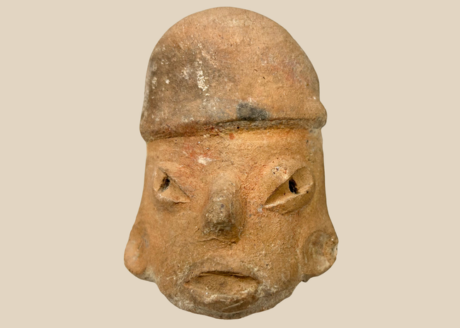 Pre-Columbian terracotta sculptural head with stylized facial features and hollow rear opening, Mesoamerica c.300 BCE–900 CE.