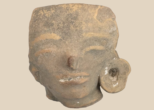 Pre-Columbian West Mexican terracotta head fragment with large ear spool mounted on a custom display stand.