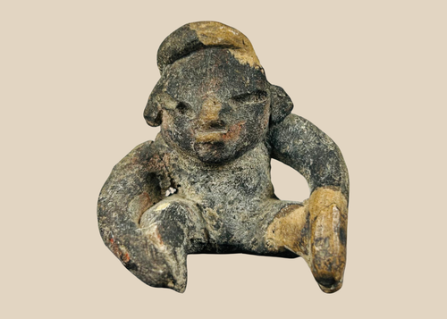 Ancient Pre-Columbian West Mexican terracotta seated figure with stylized facial features and burial encrustation