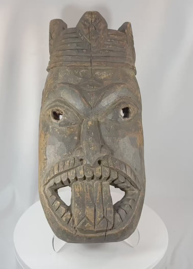 360-degree rotating view of an antique West African ceremonial mask hand-carved from hardwood, featuring recessed eyes, an elongated nose, carved teeth, a symbolic third-eye motif, and traces of aged pigment. A powerful example of traditional African ritual and tribal art.