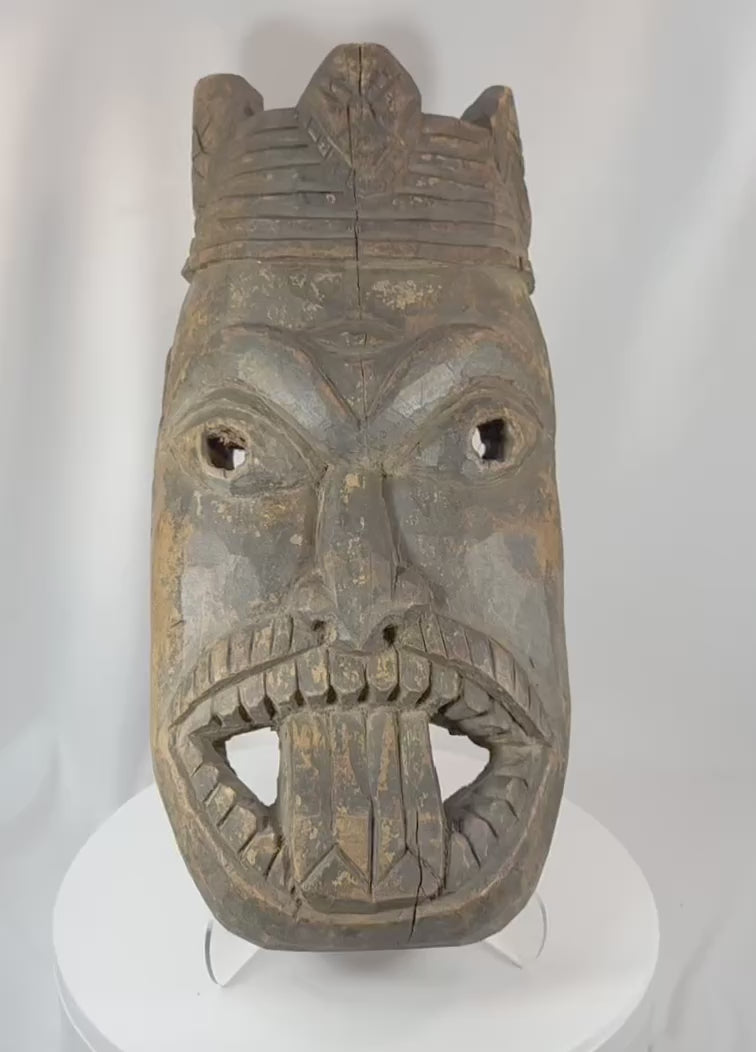 360-degree rotating view of an antique West African ceremonial mask hand-carved from hardwood, featuring recessed eyes, an elongated nose, carved teeth, a symbolic third-eye motif, and traces of aged pigment. A powerful example of traditional African ritual and tribal art.