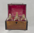 Video showing an early 19th-century Georgian mahogany boxed decanter set with brass handles, fitted interior compartments, four parcel-gilded square glass spirit decanters with stoppers, and detailed views of the historic wooden case.