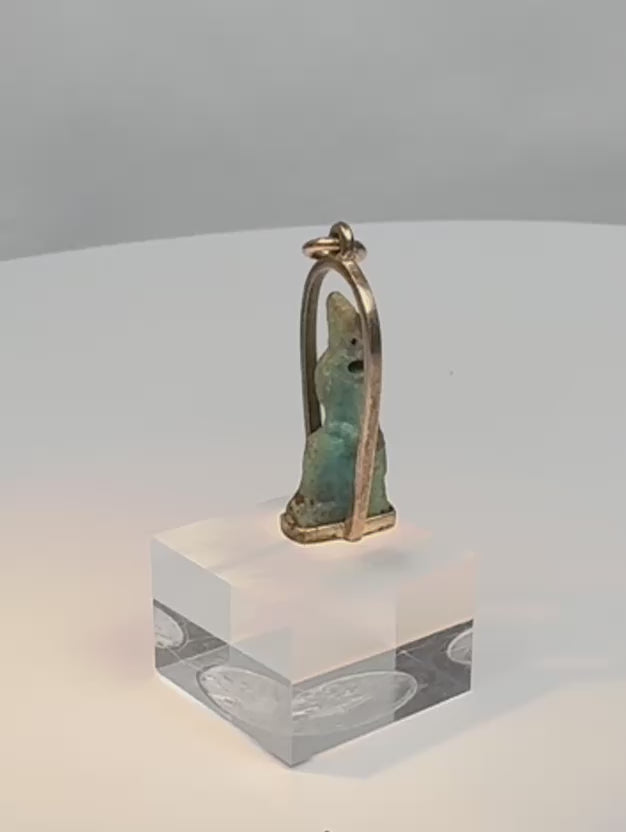 Rotating view of an ancient Egyptian blue-green faience deity amulet mounted in a later gold pendant setting