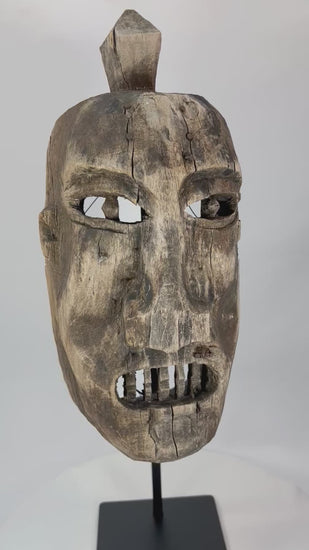 Full 360° spin of an aged tribal wooden mask showing carved eyes, teeth, and surface cracks