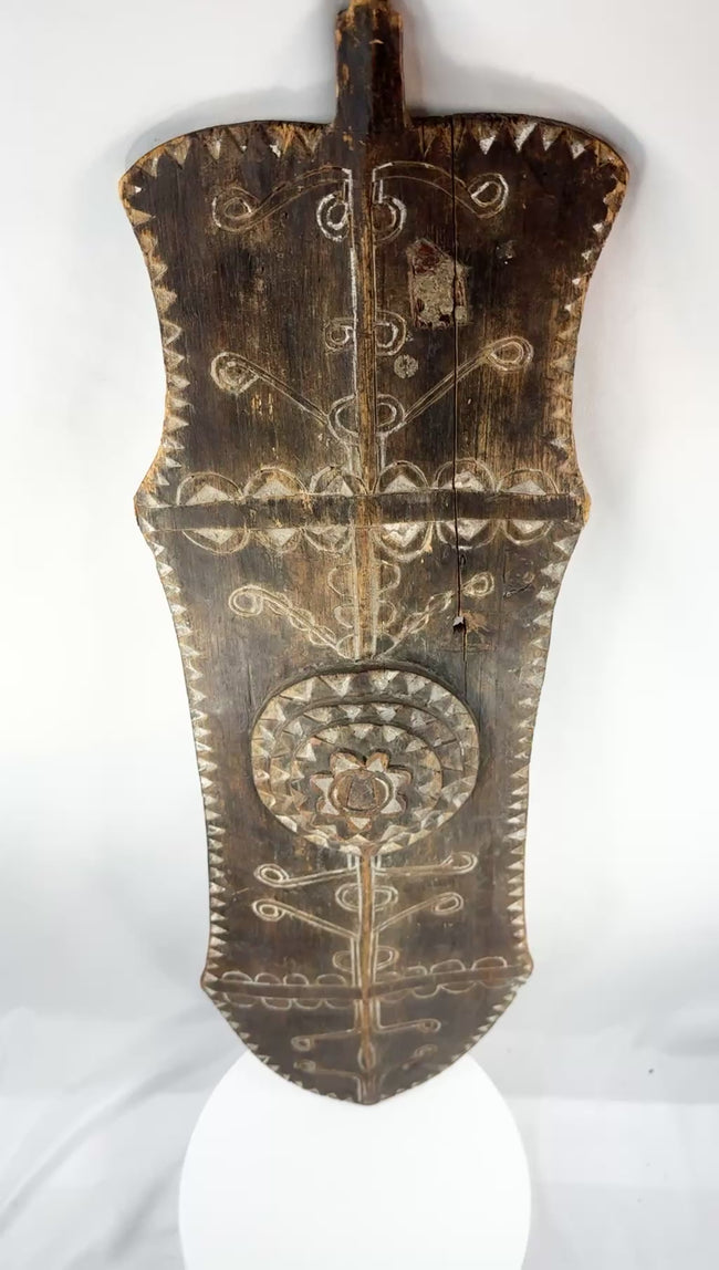Rotating presentation of an early 20th-century African carved wooden ceremonial shield with geometric decoration