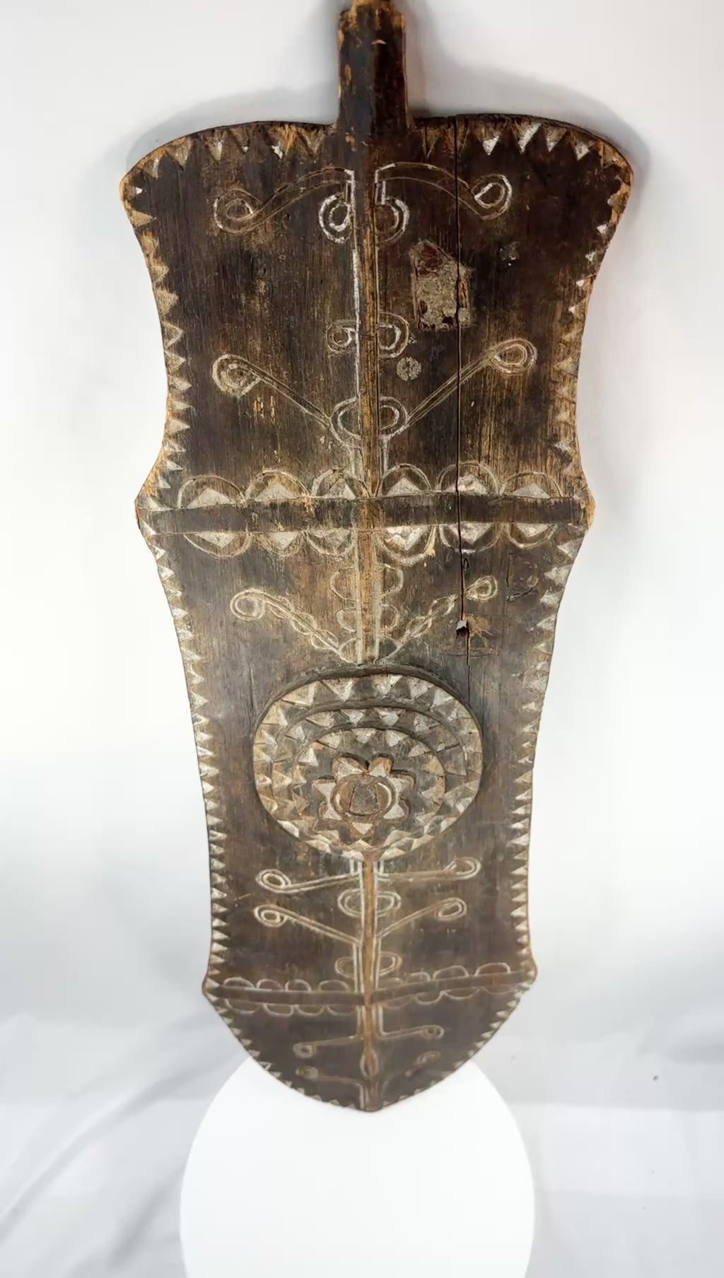 Rotating presentation of an early 20th-century African carved wooden ceremonial shield with geometric decoration