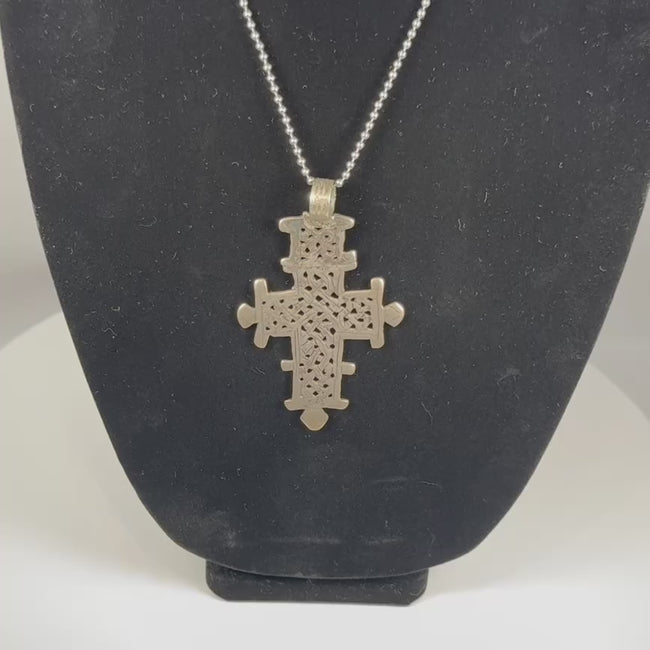 Vintage Ethiopian Coptic cross pendant featuring an intricate openwork geometric design in silver-tone metal, showcasing the distinctive craftsmanship and religious symbolism of the Ethiopian Orthodox Christian tradition from the 20th century.