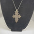 Vintage Ethiopian Coptic cross pendant featuring an intricate openwork geometric design in silver-tone metal, showcasing the distinctive craftsmanship and religious symbolism of the Ethiopian Orthodox Christian tradition from the 20th century.