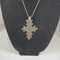 Vintage Ethiopian Coptic cross pendant featuring an intricate openwork geometric design in silver-tone metal, showcasing the distinctive craftsmanship and religious symbolism of the Ethiopian Orthodox Christian tradition from the 20th century.