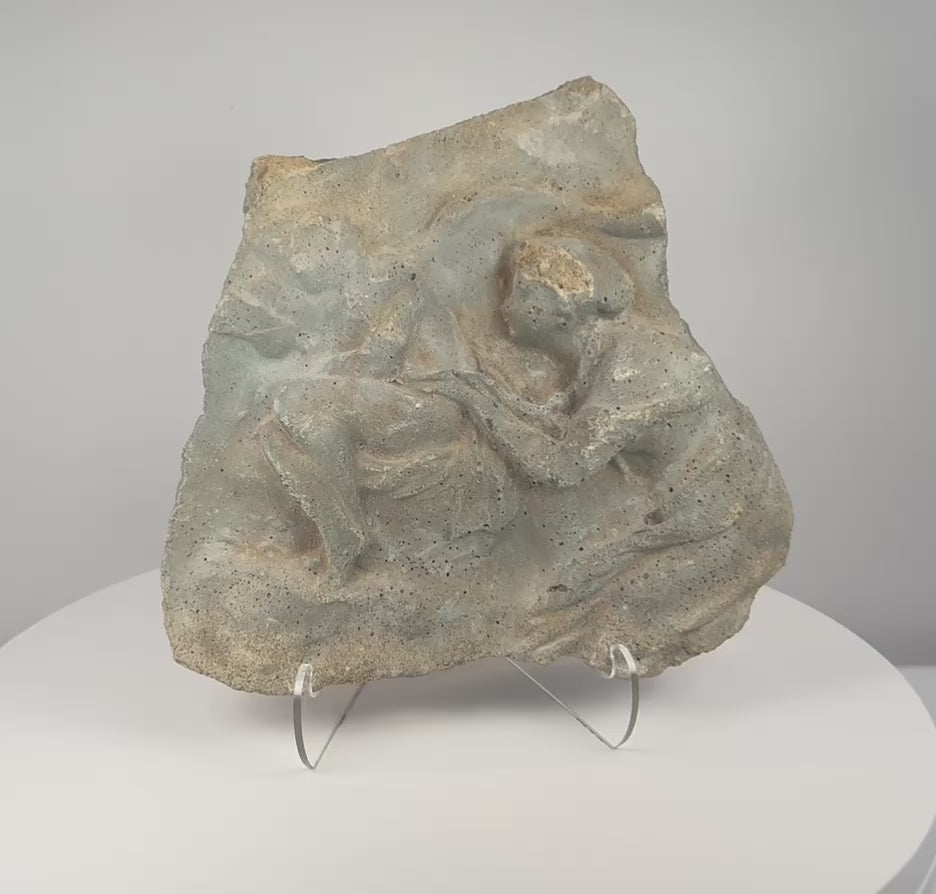 Rotating presentation of ancient Roman figural relief fragment carved in volcanic tuff, showing weathered Classical figures and porous stone texture