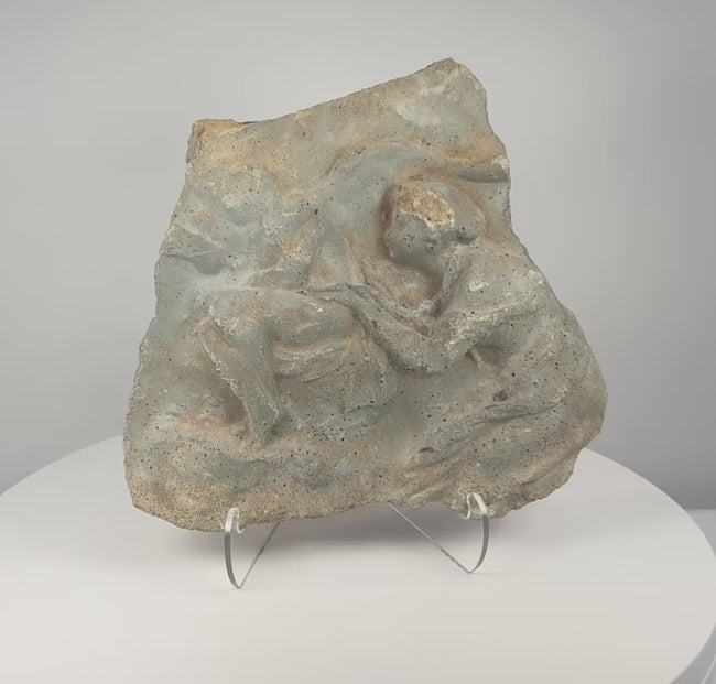 Rotating presentation of ancient Roman figural relief fragment carved in volcanic tuff, showing weathered Classical figures and porous stone texture